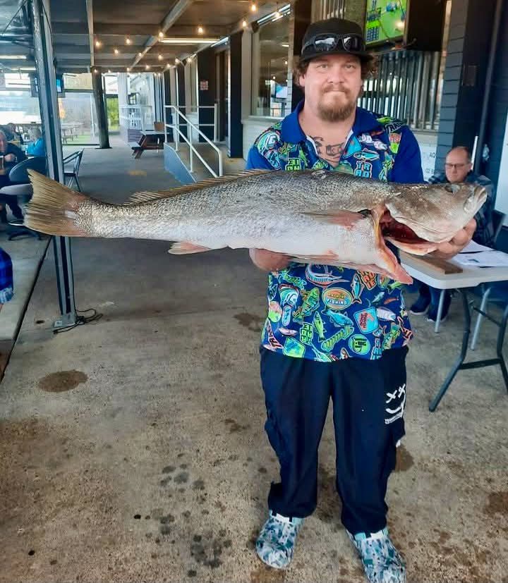 A club member carrying a large mulloway to the scales at Teralba Bowling Club
