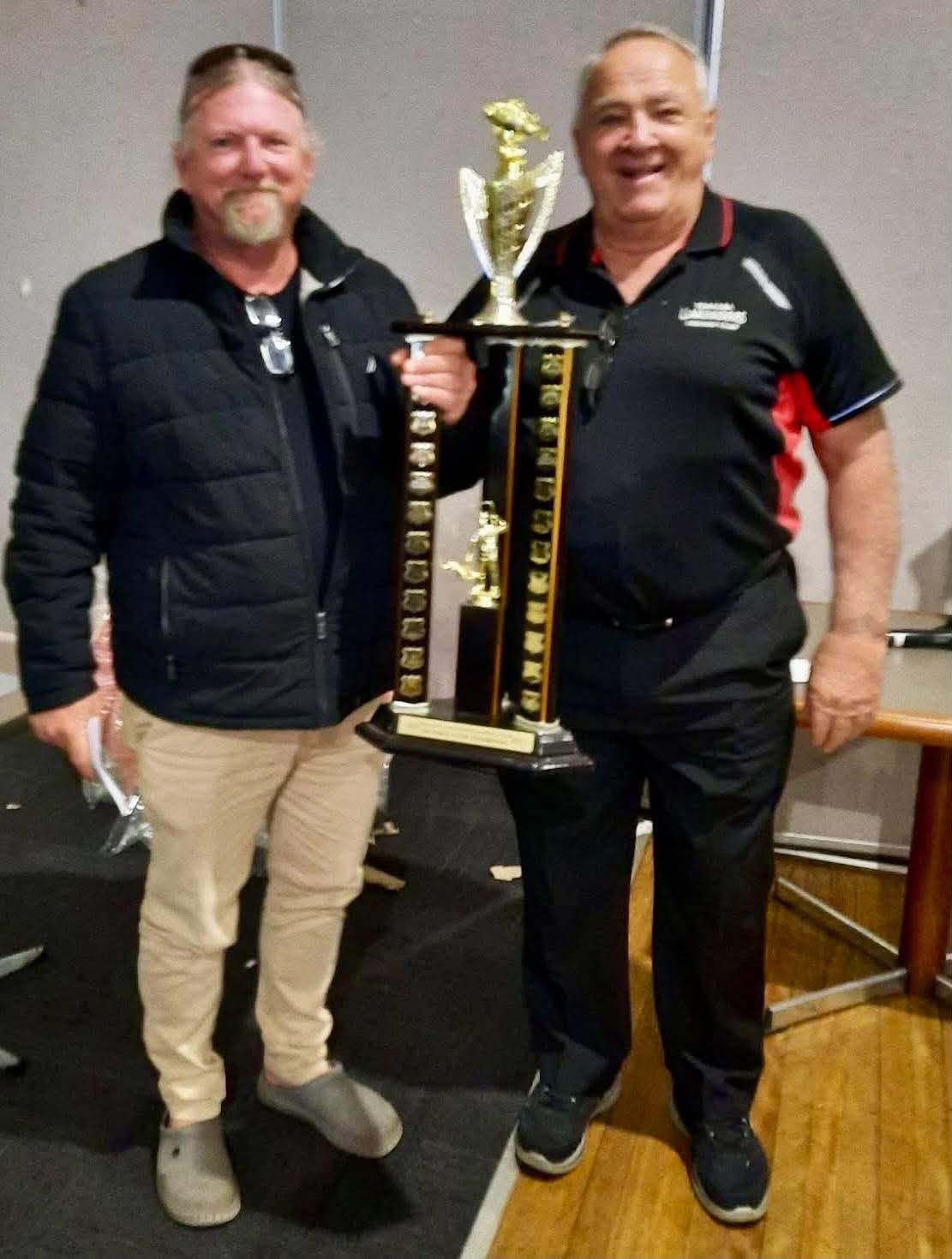 A member holding the club champion trophy at the annual presentation
