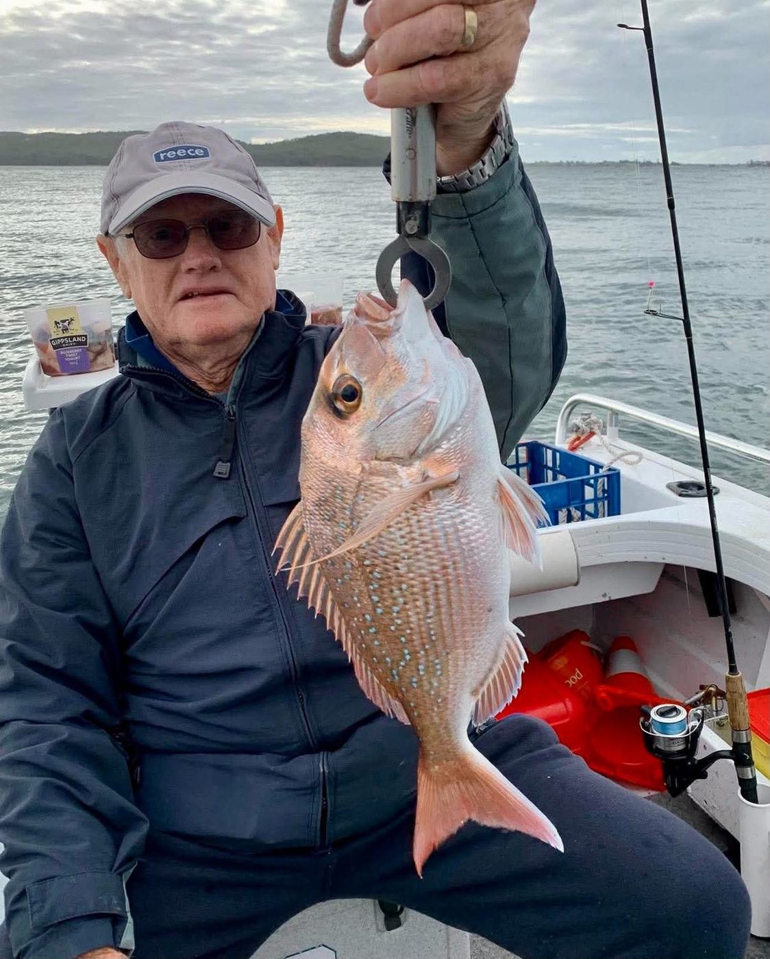 A club member holding up a snapper caught from a boat on Lake Macquarie